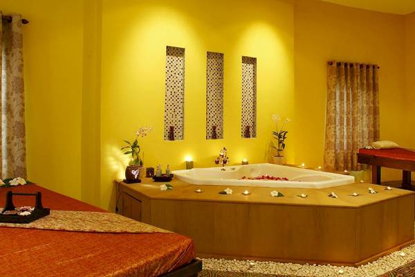 Massageraum im Peace Laguna Resort & Spa mit einem großen Whirlpool und Kerzen