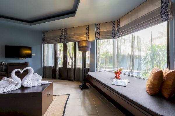 Innenansicht eines Zimmers im Peace Laguna Resort & Spa mit zwei weißen Schwanen auf einem Tisch.