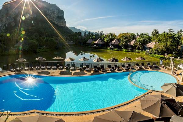 Luftaufnahme des Infinity-Pools am Peace Laguna Resort & Spa mit Sonnenuntergang und umliegenden Bungalows.