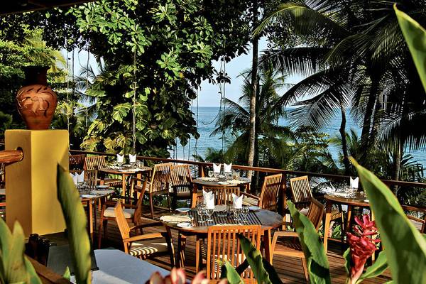 Terrasse eines Restaurants im Tango Mar Beachfront Boutique Hotel & Villas mit Blick auf den Ozean.