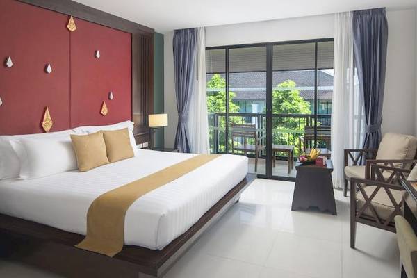 Hotelzimmer im Centara Anda Dhevi Resort & Spa mit einem Bett, Kissen, Tisch und einem Balkon