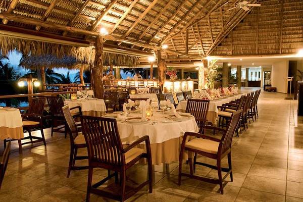 Innenansicht des Restaurants im Tango Mar Beachfront Boutique Hotel & Villas mit gedeckten Tischen und tropischer Atmosphäre.