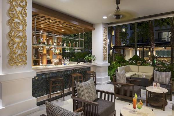Innenansicht der Bar im Centara Anda Dhevi Resort & Spa mit Bartresen, Cocktails und gemütlichen Sitzbereichen.