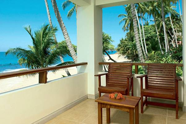 Balkon des Tango Mar Beachfront Boutique Hotel mit zwei Sesseln und einem Tisch, Blick auf den Ozean.