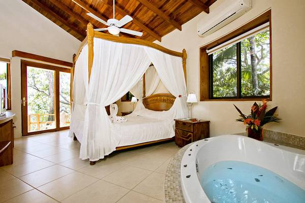 Suite im Tango Mar Beachfront Boutique Hotel mit einem Bett und einer Badewanne.