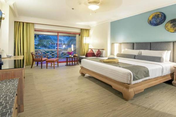 Hotelzimmer im Chada Thai Village Resort mit Bett, Balkon und Möbeln.
