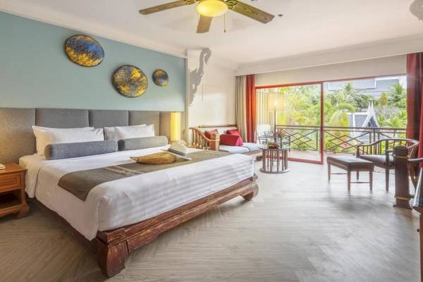 Schlafzimmer im Chada Thai Village Resort mit großem Bett, Deckenventilator und Balkon