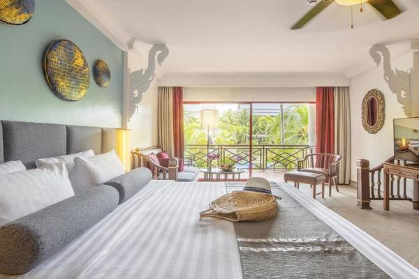 Schlafzimmer im Chada Thai Village Resort mit großem Bett, Balkon und Gartenblick.