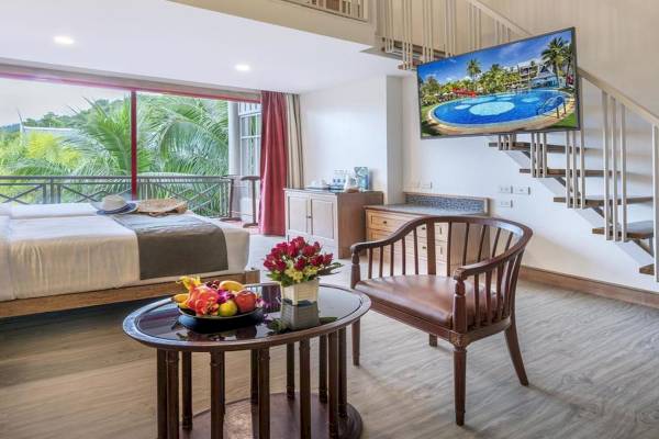 Zimmer im Chada Thai Village Resort mit Poolblick, Bett, Tisch, Stuhl und Fernseher.