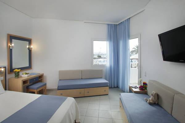 Hotelzimmer im Creta Princess Aquapark & Spa mit zwei Betten, Sofa, Schreibtisch und Fernseher.