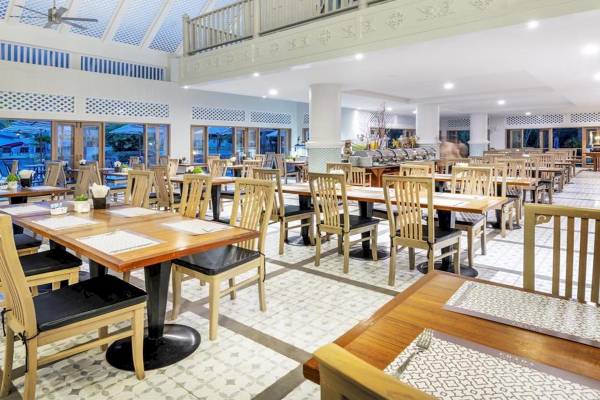 Restaurant im Chada Thai Village Resort mit modernen Möbeln und großen Fenstern.