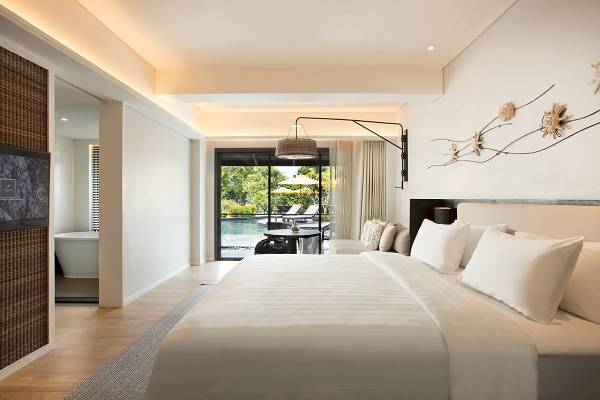Schlafzimmer im ShellSea Krabi Hotel mit großem Bett und Poolblick.