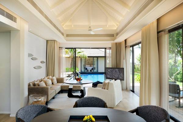 Innenansicht des ShellSea Krabi Wohnzimmers mit Poolsicht, modernen Möbeln und weichen Kissen.