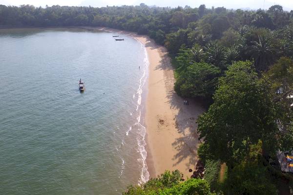 Luftaufnahme des ShellSea Krabi Strandes mit mehreren Booten im Wasser und Gästen auf dem Gelände.