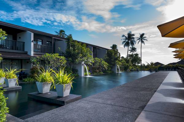 Poolbereich des ShellSea Krabi Hotels mit Pflanzen und Wasserbrunnen.