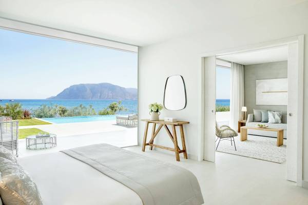 Schlafzimmer mit Meerblick im Ikos Aria Hotel, modernes Design mit großen Fenstern.