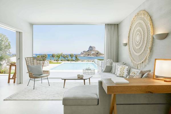 Wohnzimmer im Hotel Ikos Aria mit Blick auf den Pool und das Meer.