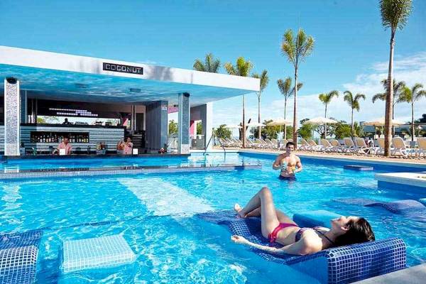 Poolbar im Riu Palace Costa Rica mit Liegen, Sonnenschirmen und Palmen
