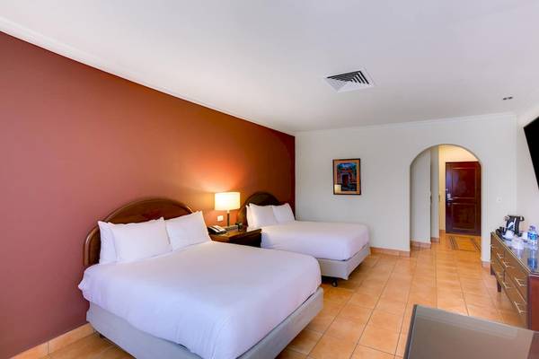 Doppelzimmer im DoubleTree by Hilton Hotel Cariari San Jose mit zwei Betten, Nachttischen und Fernseher.