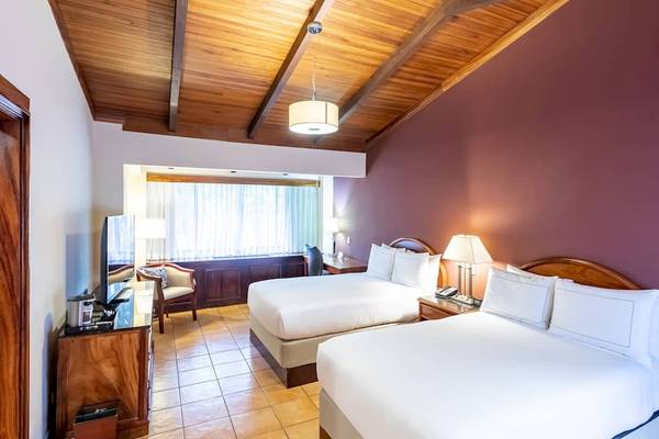Doppelzimmer im DoubleTree by Hilton Hotel Cariari San Jose mit zwei Betten, Fernseher und Schreibtisch.