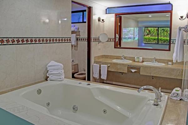 Badezimmer im DoubleTree by Hilton Hotel Cariari San Jose mit Badewanne, Waschbecken und Spiegel.