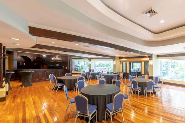 Bankettsaal im DoubleTree by Hilton Hotel Cariari San Jose mit runden Tischen, Stühlen und großen Fenstern.