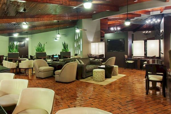 Loungebereich des DoubleTree by Hilton Hotel Cariari San Jose mit Möbeln und Pflanzen.