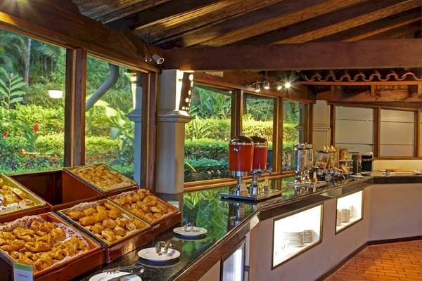 Frühstücksbuffet im DoubleTree by Hilton Hotel Cariari San Jose mit verschiedenen Gebäcksorten und Blick auf den Garten