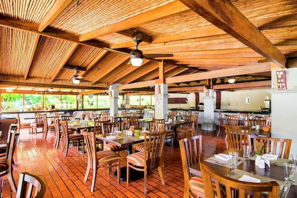 Innenansicht des Restaurants im DoubleTree by Hilton Hotel Cariari San Jose mit hölzernen Decken und Tischen.