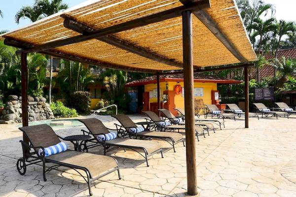 Außenbereich des DoubleTree by Hilton Hotel Cariari San Jose mit Liegestühlen und Pool.