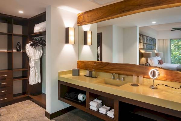 Badezimmer im El Mangroove, Autograph Collection Hotel mit Doppelwaschbecken, Spiegel und Kleiderschrank.