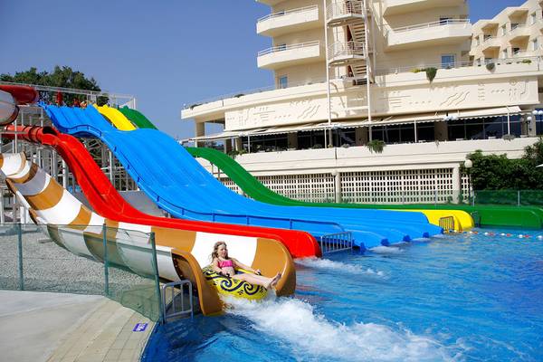 Mädchen rutscht auf einer gelben Wasserrutsche im Creta Princess Aquapark