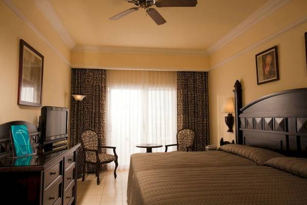 Hotelzimmer im Riu Guanacaste mit Doppelbett, Fernseher, und Möbeln.