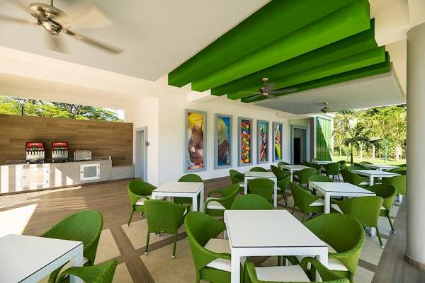 Innenansicht des Restaurants im Riu Guanacaste Hotel mit grünen Stühlen und Tischen.