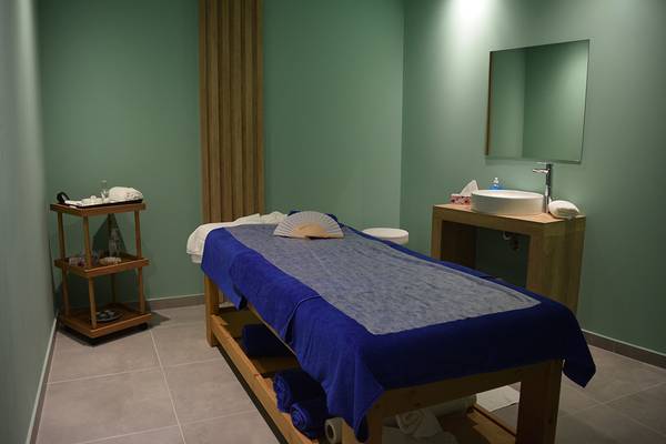 Massageraum im Creta Princess Aquapark & Spa Hotel mit blauer Decke und grünen Wänden.