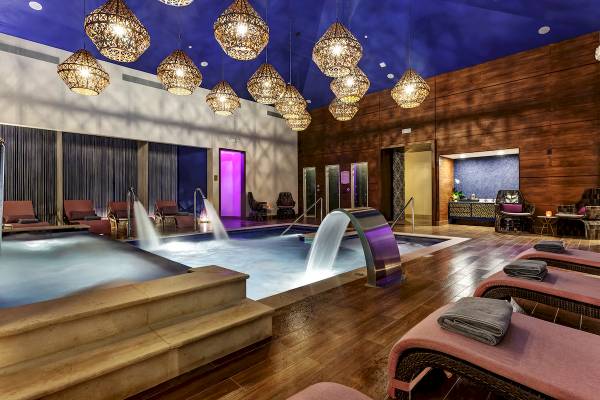 Innenpoolbereich des Planet Hollywood Beach Resorts mit Lounge-Sesseln und Wasserfontänen.