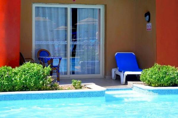 Außenbereich eines Hotels mit einem Pool, Loungestühlen und einem Tisch
