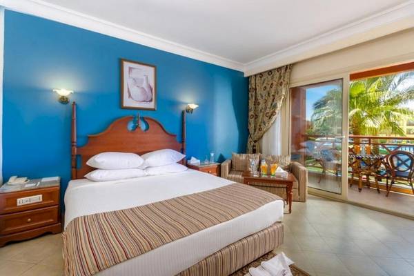 Hotelzimmer im Titanic Beach Spa & Aqua Park mit blauen Wänden, Doppelbett und Balkonzugang.