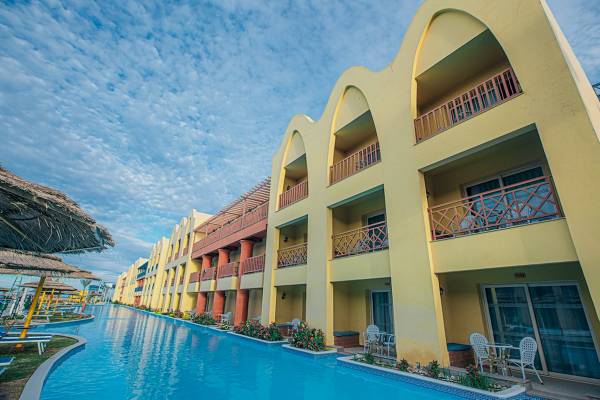 Ein Hotel mit einem großen Schwimmbad und Terrassen, umgeben von Pflanzen und Sonnenliegen.