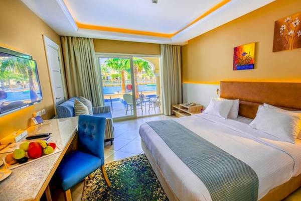 Innenansicht eines Zimmers im Titanic Royal Hotel mit Bett, Schreibtisch und Balkon.