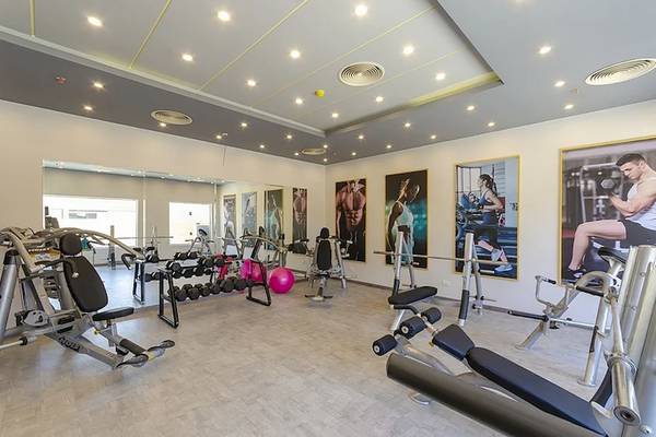 Innenansicht des Fitnesscenters im Titanic Royal Hotel mit verschiedenen Geräten und Plakaten.