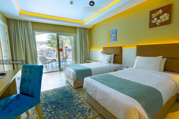 Doppelzimmer im Titanic Royal Hotel mit zwei Betten, Blick auf den Pool und Terrasse