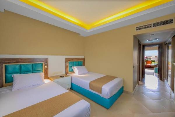 Doppelzimmer im Titanic Resort & Aqua Park mit zwei Betten, Nachttischen und einem offenen Tür.