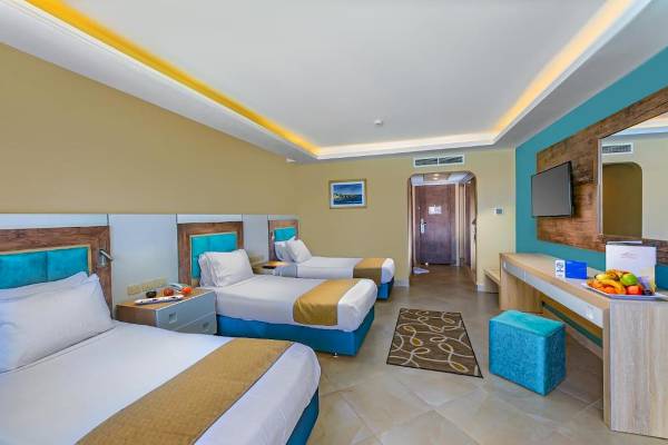 Dreibettzimmer im Titanic Resort & Aqua Park Hotel mit drei Betten und einem Fernseher.