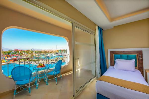 Zimmer mit Balkon im Titanic Resort & Aqua Park mit Blick auf einen Pool und Wasserrutschen.