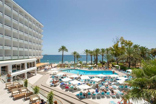 Außenbereich des Vibra Algarb Hotels mit Swimmingpool, Sonnenliegen und Palmen am Meer