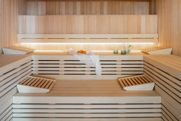 Innenansicht der Sauna im Zel Mallorca Hotel mit Holzbänken, einem weißen Handtuch und Orangen