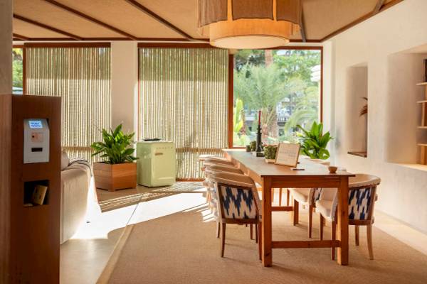 Esstisch und Sofa im Zel Mallorca Hotel mit Pflanzen und Lampen.