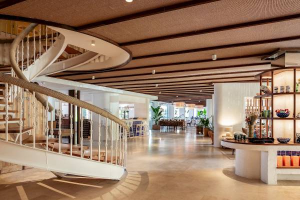 Innenbereich des Zel Mallorca Hotels mit einer Wendeltreppe, Sitzbereich und Pflanzen.