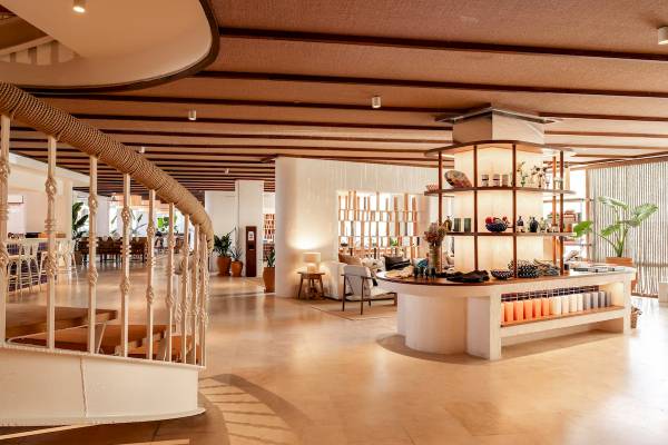 Innenbereich des Zel Mallorca Hotels mit offener Lobby und Holzmöbeln.